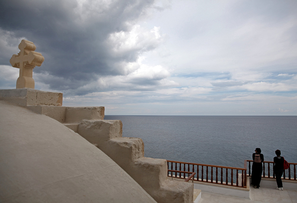 Pilgrims look at the horizon at the Greek Orthodox Monastery of Apostolos Andreas in Karpasia, Cyprus, in 2016. (CNS/Reuters/Yiannis Kourtoglou)