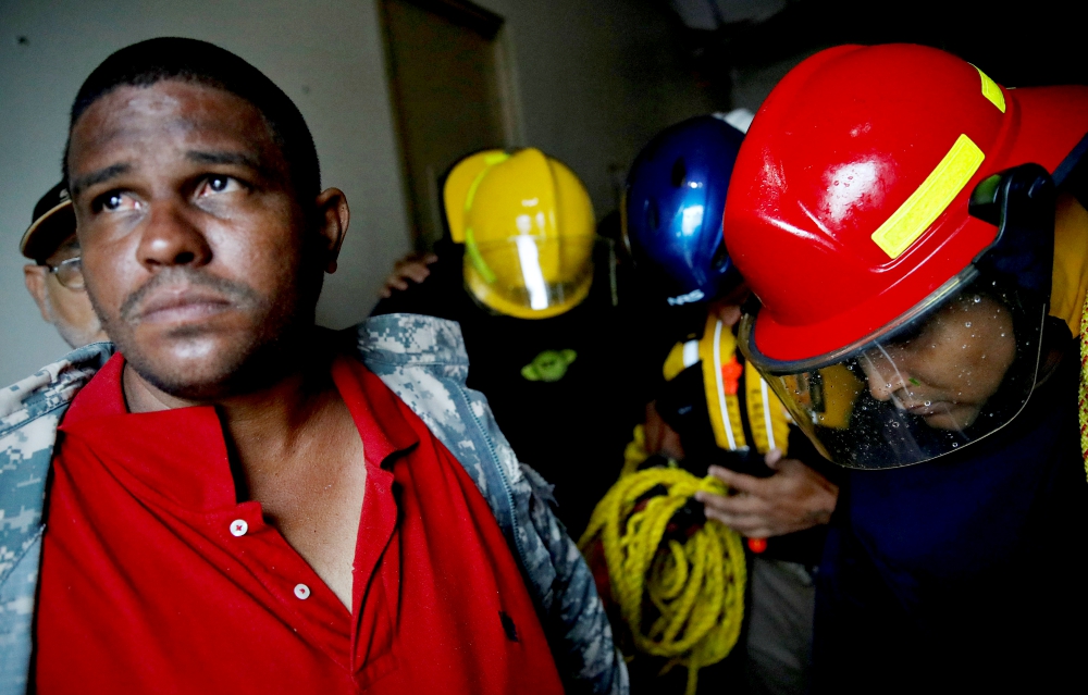 Rescue workers pray before walking out from the Emergency Operation Center in Guayama, Puerto Rico, after Hurricane Maria hit Sept. 20. (CNS/Reuters/Carlos Garcia Rawlins)