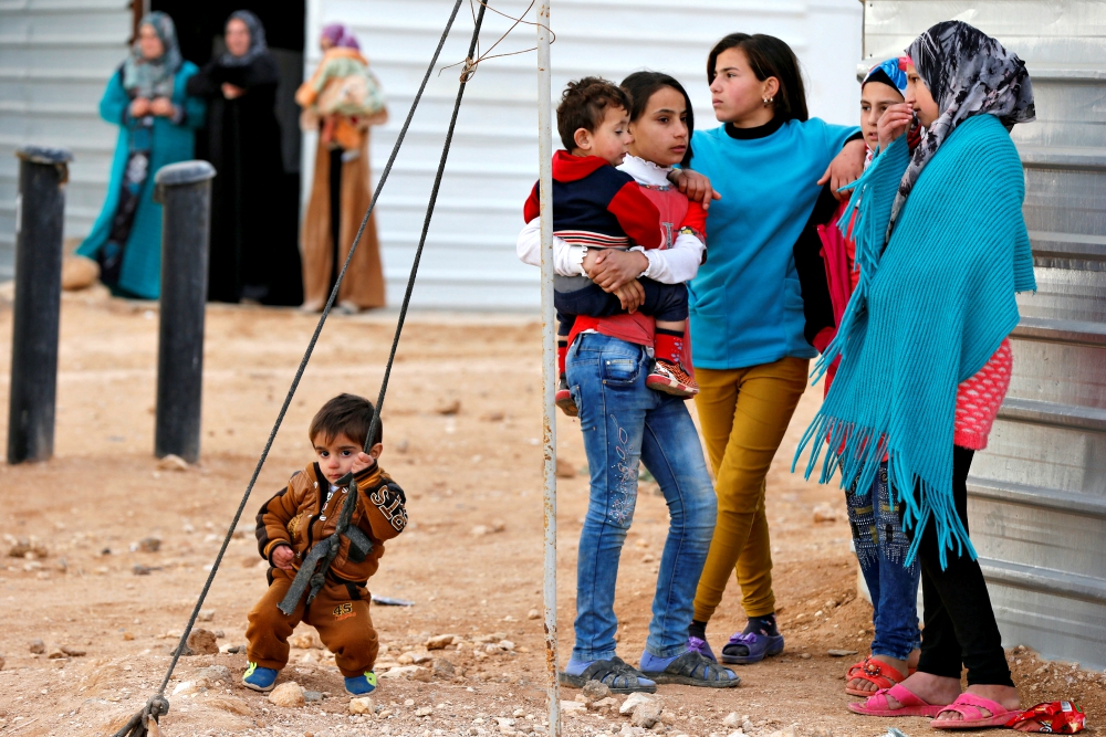 Syrian refugees wait outside their shelters in January 2018 at Zaatari camp near Mafraq, Jordan. (CNS/Reuters/Muhammad Hamed)