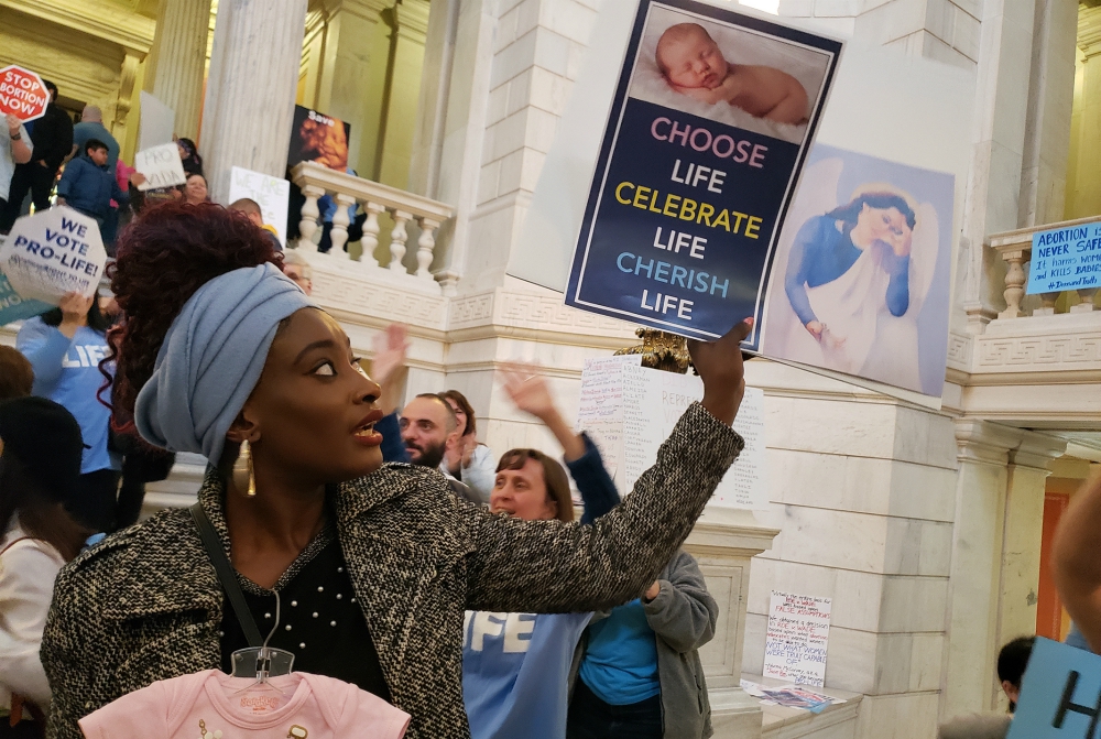 Elizabeth Koroma of Providence, Rhode Island, holds a pro-life sign in the rotunda of the Rhode Island Statehouse May 14 to protest a Senate bill aimed at expanding legal abortion in Rhode Island. The judiciary committee voted against the measure. (CNS)