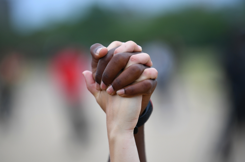 A man and woman hold hands in London's Hyde Park during a Black Lives Matter protest June 3. (CNS/Reuters/Dylan Martinez)