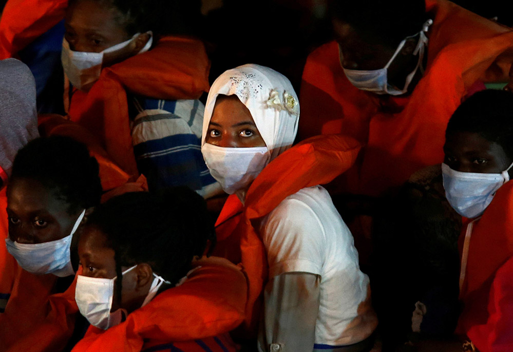 Rescued migrants look out from an Armed Forces of Malta vessel upon their arrival in Valletta, Malta, Aug. 3, 2020.