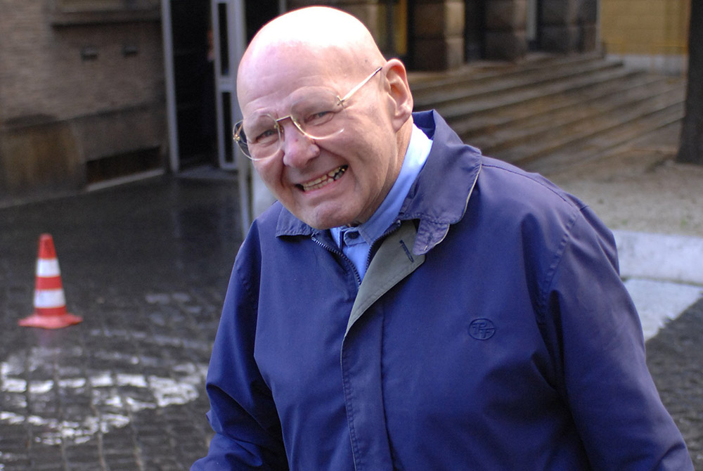 Wearing his trademark blue workman’s uniform, Discalced Carmelite Fr. Reginald Foster is photographed near the Vatican post office in this January 2007 file photo. (CNS/Chris Warde-Jones)