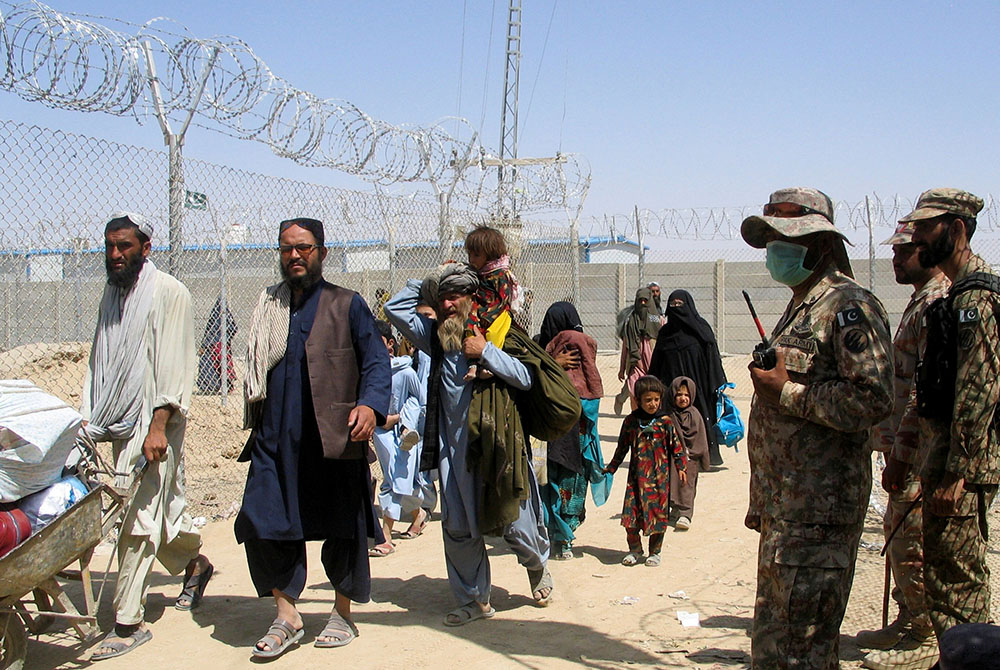 People arriving from Afghanistan make their way through the Friendship Gate crossing point Aug. 19 at the Pakistan-Afghanistan border town of Chaman, Pakistan. (CNS/Saeed Ali Achakzai, Reuters)