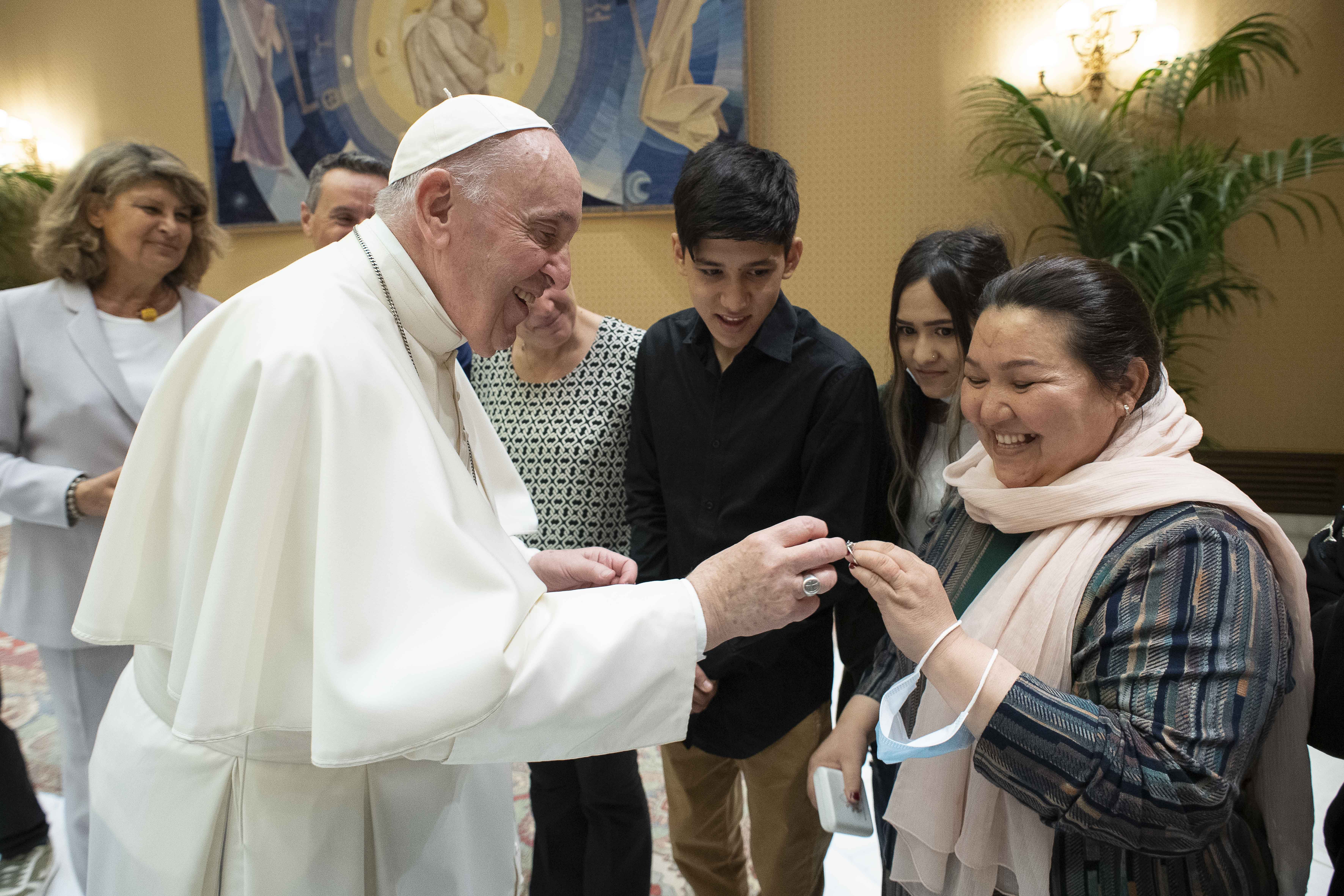 Pope Francis accepts a wedding ring from a woman whose husband was killed by the Taliban, during a meeting with families from Afghanistan prior to his general audience in the Paul VI hall at the Vatican Sept. 22, 2021. The pope met three Christian familie