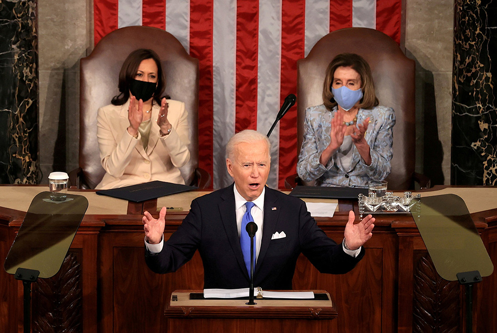 President Joe Biden addresses a joint session of Congress April 28 in Washington, as Vice President Kamala Harris and Speaker of the House U.S. Rep. Nancy Pelosi, D-Calif., applaud. (CNS/Chip Somodevilla, Pool via Reuters)