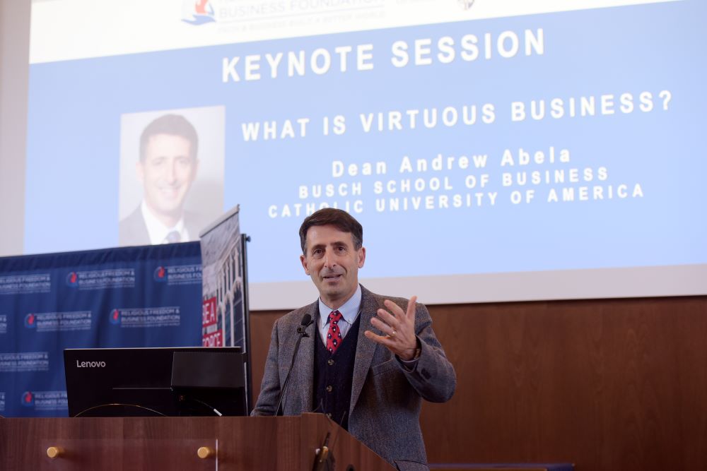 Man speaking in front of screen 