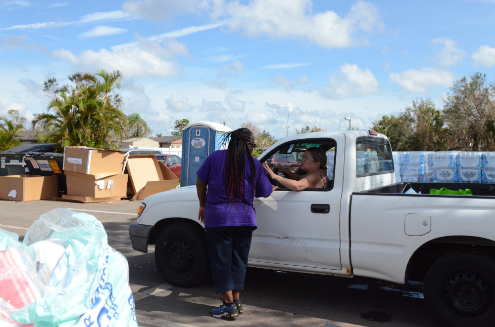 Lizvelle Rivera sits in a pickup truck and thanks a Catholic Charities Diocese of Venice volunteer for the supplies she received Oct. 10, 2022.