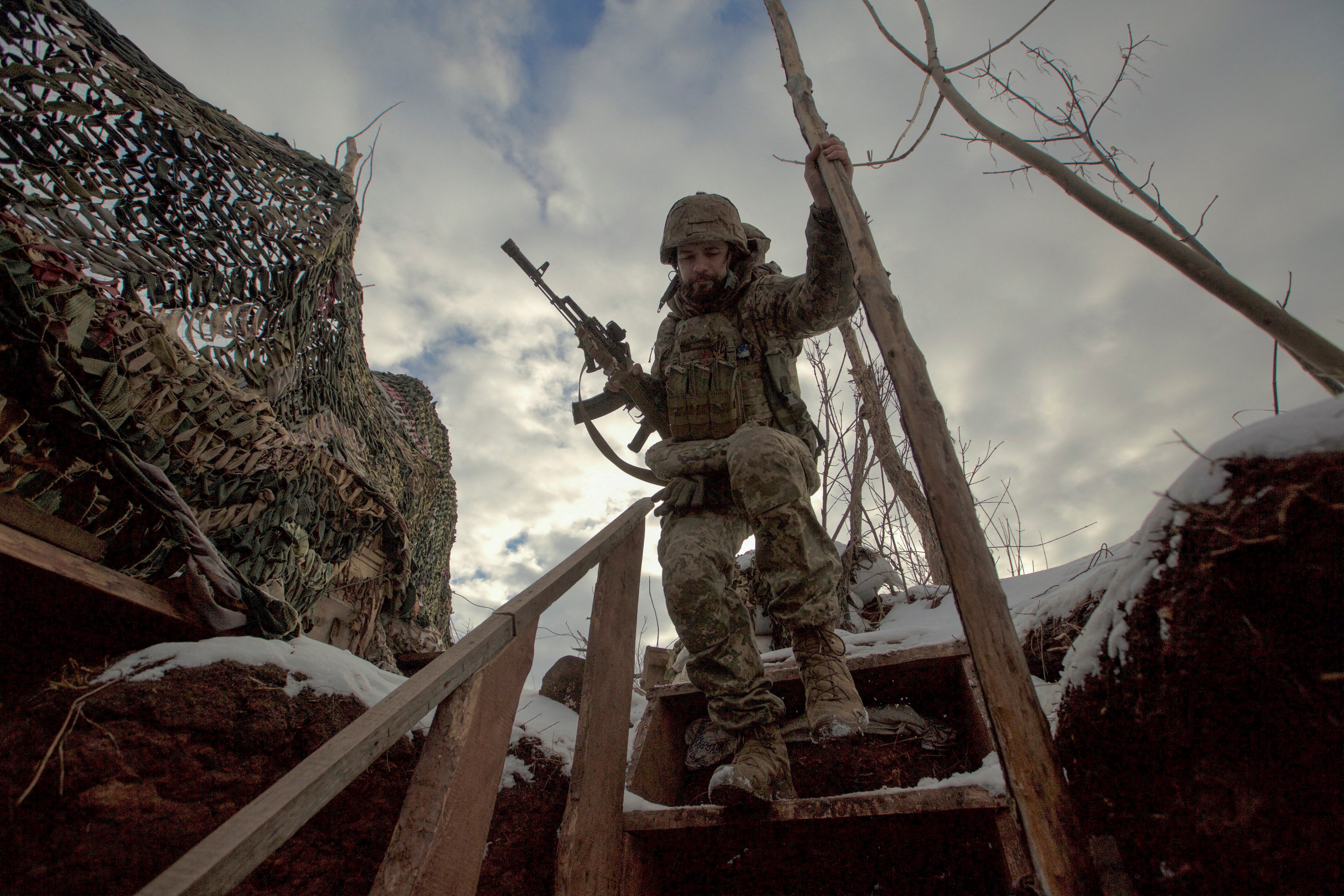 A service member with the Ukrainian armed forces walks past combat positions near a line of separation from Russian-backed rebels near Horlivka in the Donetsk region of Ukraine Jan. 22. (CNS/Reuters/Anna Kudriavtseva)