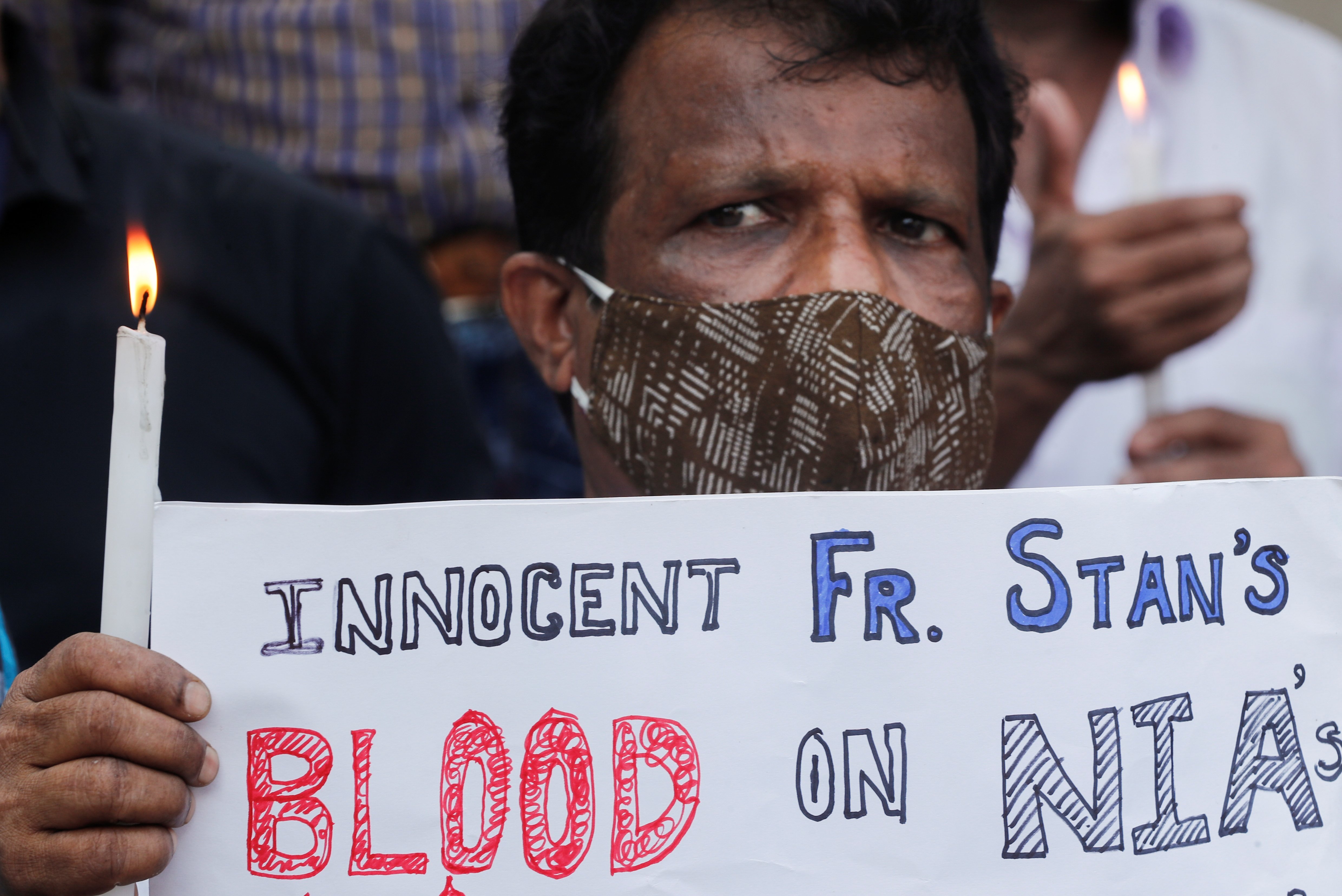 A man holds a candle during a prayer service for Jesuit Father Stan Swamy in Mumbai, India, July 6, 2021, a day after he died at a hospital. (CNS photo/Francis Mascarenhas, Reuters)