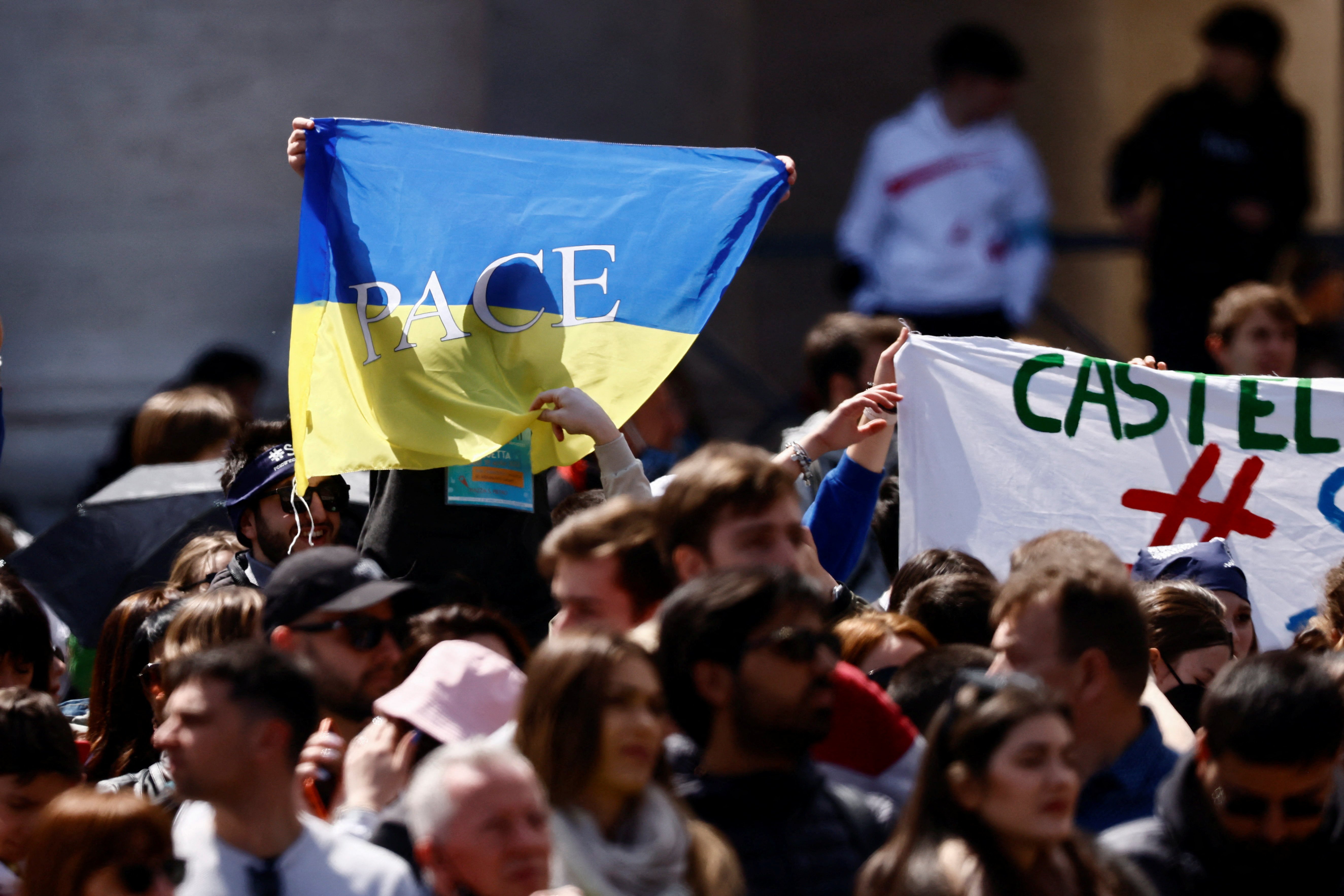 A pilgrim holds a Ukrainian flag as Pope Francis leads the "Regina Coeli" from the window of his studio overlooking St. Peter's Square at the Vatican April 18, 2022. (CNS photo/Yara Nardi, Reuters)