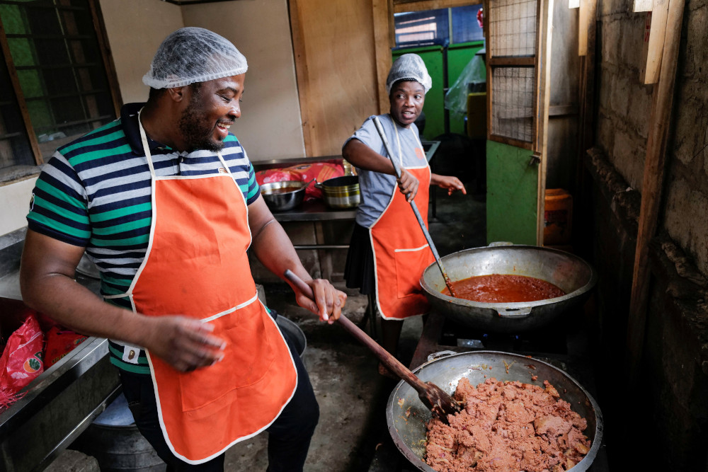 Chef Elijah Amoo Addo and cook Angel Laryea of Food For All Africa prepare free lunch to reduce food waste and feed those in need in Accra, Ghana, June 3, 2022. (CNS photo/Francis Kokoroko, Reuters)