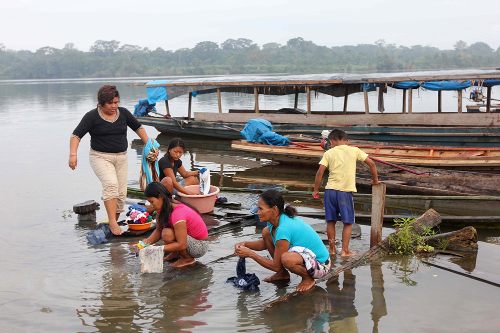 Residents of Dos de Mayo, Peru, wash their clothes in a lake in 2014. Water, soil and sediments in the Amazon tributary contain heavy metals and other residue from more than four decades of oil production. (CNS/Barbara Fraser)