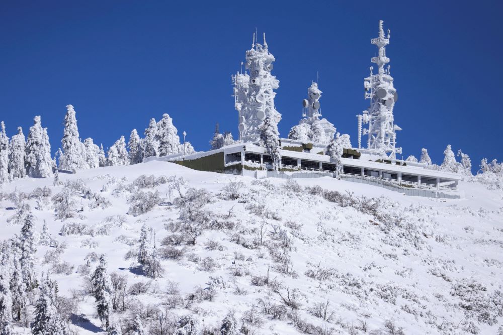 Snow-covered building pictured in snow-filled area.