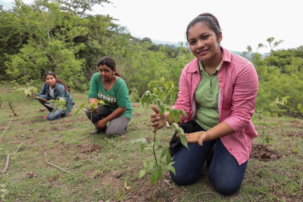 Ruth Noemi Lima Corado, 20, of the RainDrop founding group, Selena Claribel Escalante Orantes (foreground), 26, Raindrop's plant cover monitor, and Jennifer Rebeca Avila Ruiz, 21, RainDrop intern seen during a planting day of trees with community members in Bosque San Lorenzo, in Ahuachapán, El Salvador. 