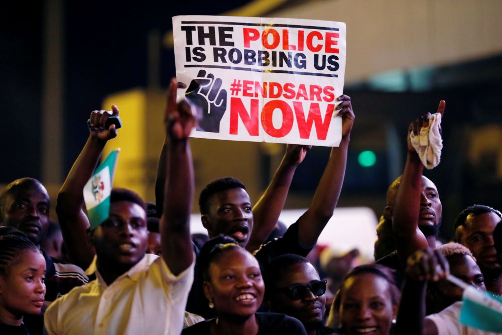 A demonstrator holds a sign during protest in Lagos, Nigeria, Oct. 17, 2020, over alleged police brutality by SARS, or Special Anti-Robbery Squad. The police unit, created in 1992, had long been accused of harassing and physically abusing civilians. It was disbanded in October 2020. (CNS photo/Reuters/Temilade Adelaja)