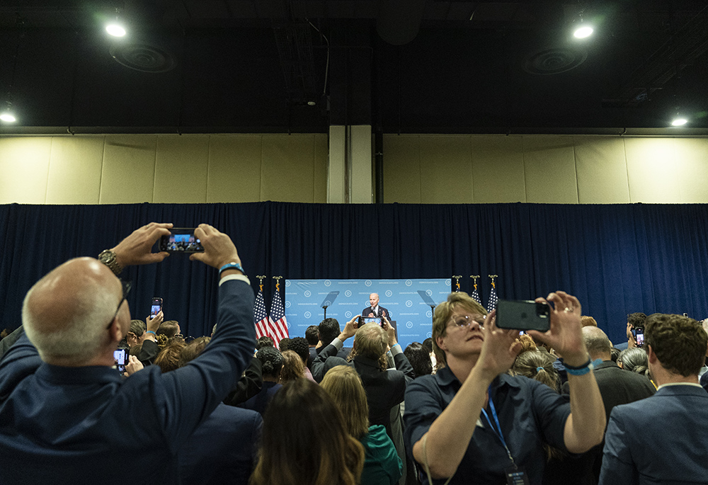 Supporters take pictures as President Joe Biden speaks at a Democratic National Committee event at the Gaylord National Resort and Convention Center, Sept. 8, 2022, in Oxon Hill, Maryland. (AP photo/Alex Brandon)