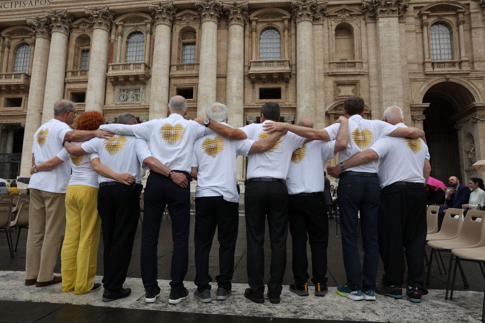 Eight men and one woman stand facing St. Peter's Basilica at the end of Pope Francis' weekly general audience in St. Peter's Square at the Vatican May 17. 