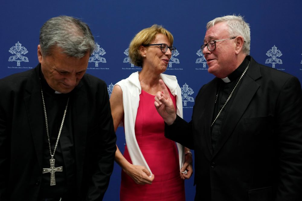 Helena Jeppesen Spuhler, center, talks with Cardinal Jean-Claude Hollerich, right, and Secretary General of the Synod of Bishops Cardinal Mario Grech at the end of a presentation of the new guidelines for the Synod of Bishops at the Vatican June 20. (AP/Domenico Stinellis)