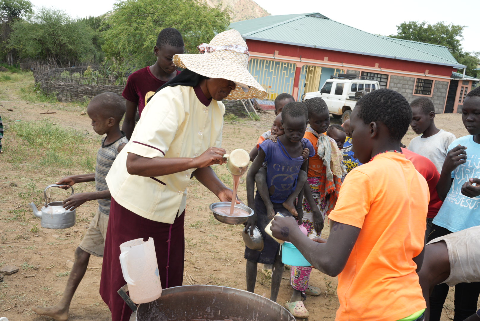 Sr. Jannifer Hiuhu serves porridge to children next to the East Pokot's Incarnate Word Sisters' convent. For most of these children who attend the congregation's Rotu Primary School, the sisters' "Porridge for Breakfast" initiative is their only meal of the day, as their nomadic families leave them at home in search of pasture amid a ravaging drought. (GSR photo/Wycliff Peter Oundo)