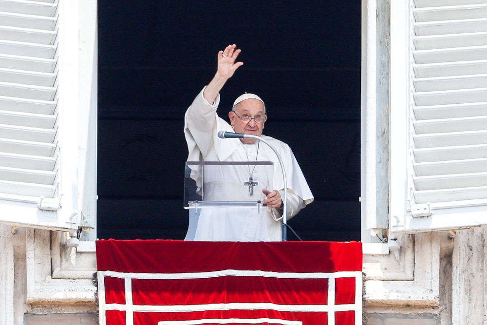 Pope Francis smiles and waves at visitors gathered in St. Peter's Square at the Vatican after praying the Angelus June 18. (CNS/Lola Gomez)