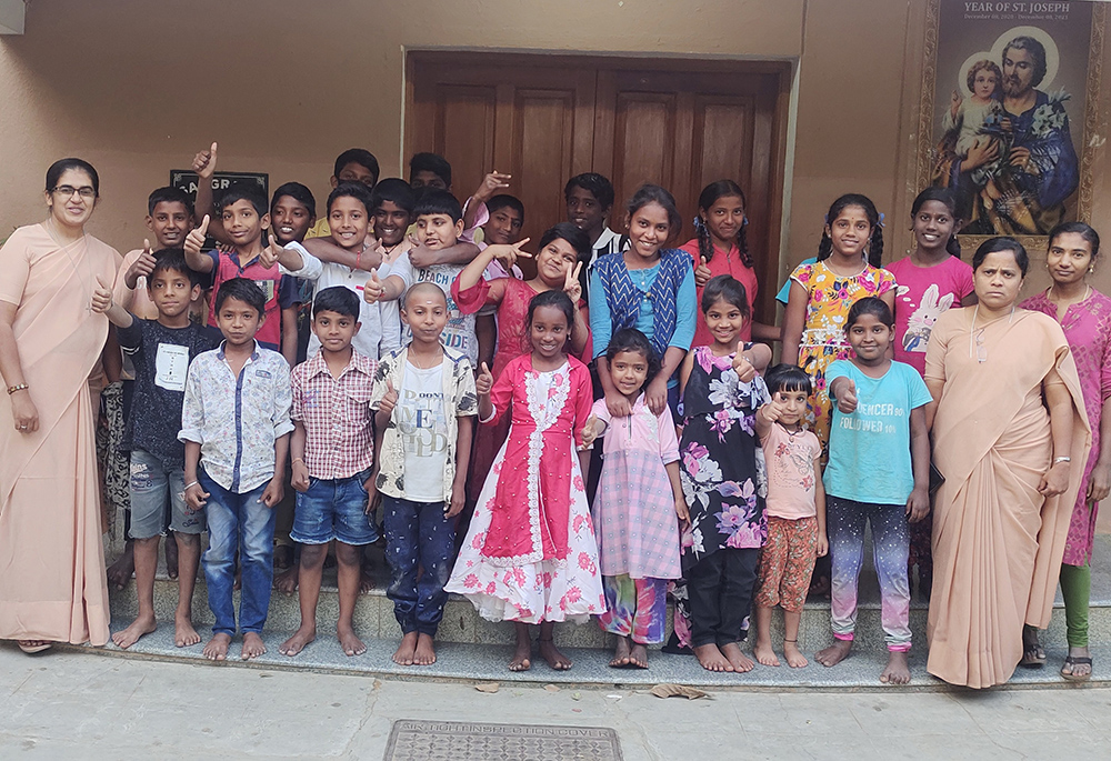 Children get ready to sing "happy birthday" to Priya Raj (far right), a resident in Sangraha, a shelter home managed by the St. Joseph of Tarbes congregation in the southern Indian city of Bengaluru. Sister Mariamma (front left) and Sr. Irudaya Mary (front right) pose with children. (Thomas Scaria)