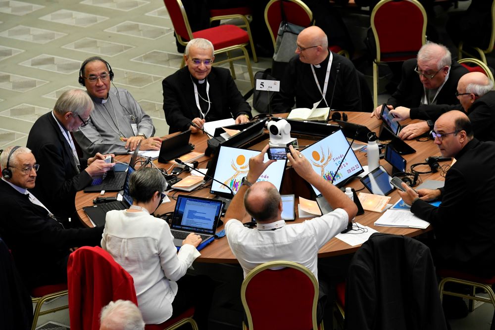 People sit and talk around a round table. 