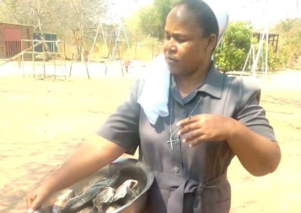 Woman holds a large bowl with fish.