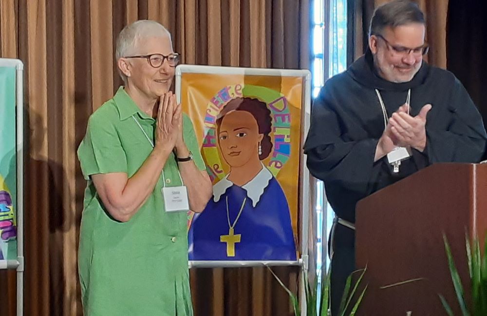 Marie Dennis claps after receiving award. Bishop Stowe is at right, 