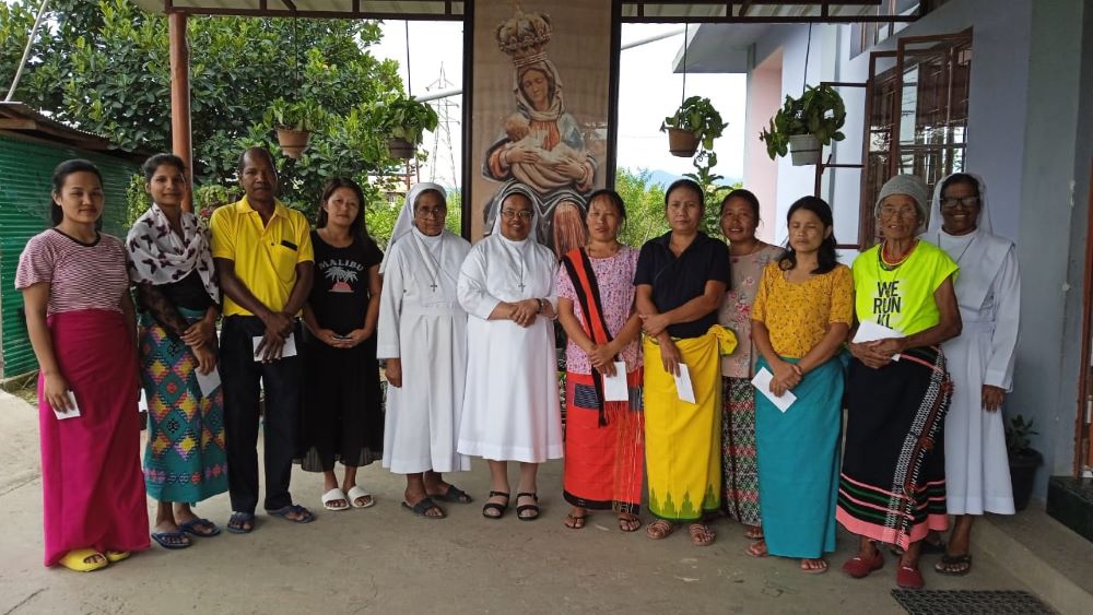 A group of people stand in a line, two nuns at the center. 