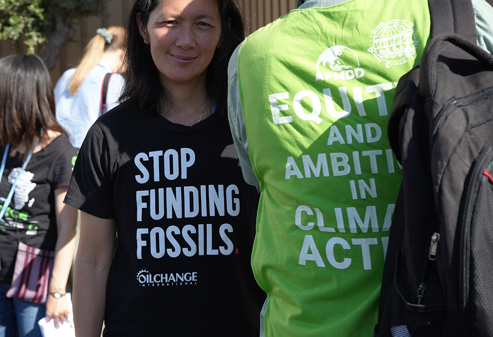 A protester wears a t-shirt with the message "Stop funding fossils" during a demonstration at the COP27 climate summit in Sharm el-Sheikh, Egypt, Nov. 9, 2022. Over 50 activists of all ages and backgrounds took over the so-called "Blue Zone" — the central area of the conference center in Sharm el-Sheikh — to chant, "Stop funding fossil fuels! Stop funding death!" (EarthBeat photo/Doreen Ajiambo)