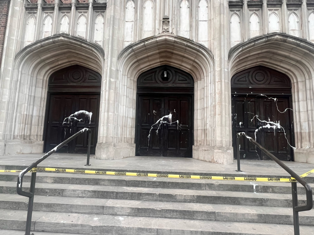 White paint is splattered across three wooden double doors at the top of stairs