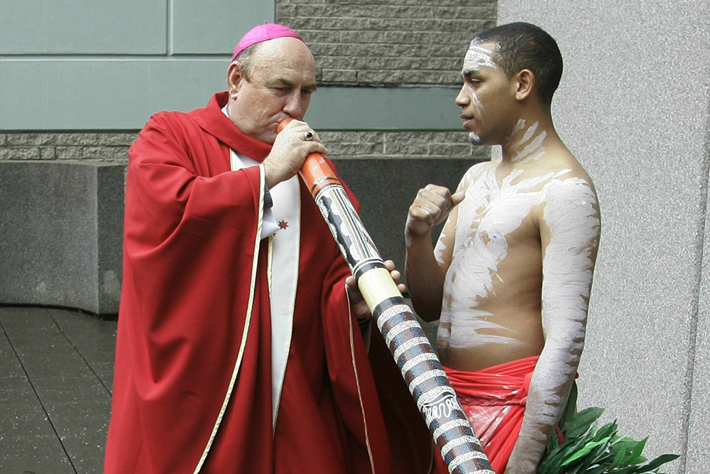 Bishop Christopher Saunders of Broome tries to play a didgeridoo during a World Youth Day media event in Sydney, Australia, on April 17, 2008. Saunders, a retired Catholic bishop, has been charged Feb. 22, 2024, with child sex abuse offenses in a remote part of Australia's northwest. (AP/Rob Griffith, File)