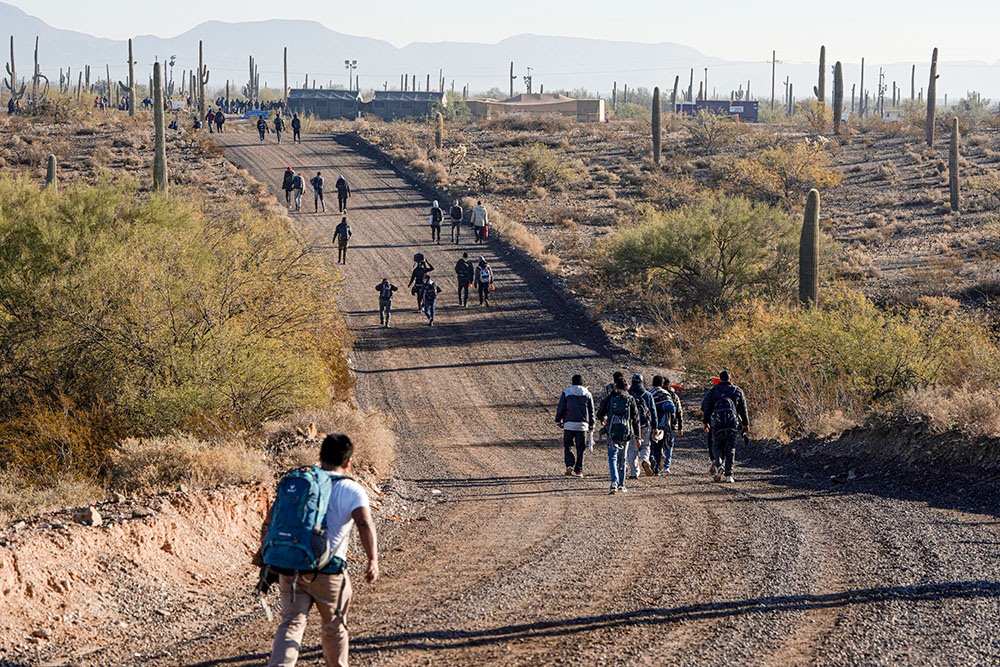 Migrants walk to a processing facility as directed by Border Patrol at the U.S.-Mexico border near Lukeville, Arizona, Dec. 25, 2023. (OSV News/Reuters/Rebecca Noble)