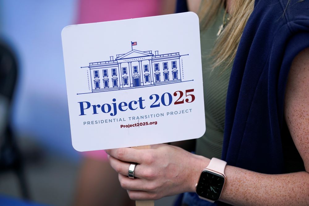 Kristen Eichamer holds a Project 2025 fan in the group's tent at the Iowa State Fair, Aug. 14, 2023, in Des Moines, Iowa.