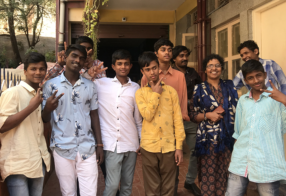 Anand and Ayyappan (far left) and their peers are pictured with Gleaners of the Church member Silvy Lawrence Pazherickal, in front of BOSCO Yuvakendra, a youth center for street children in Bengaluru, southern India. (Thomas Scaria)