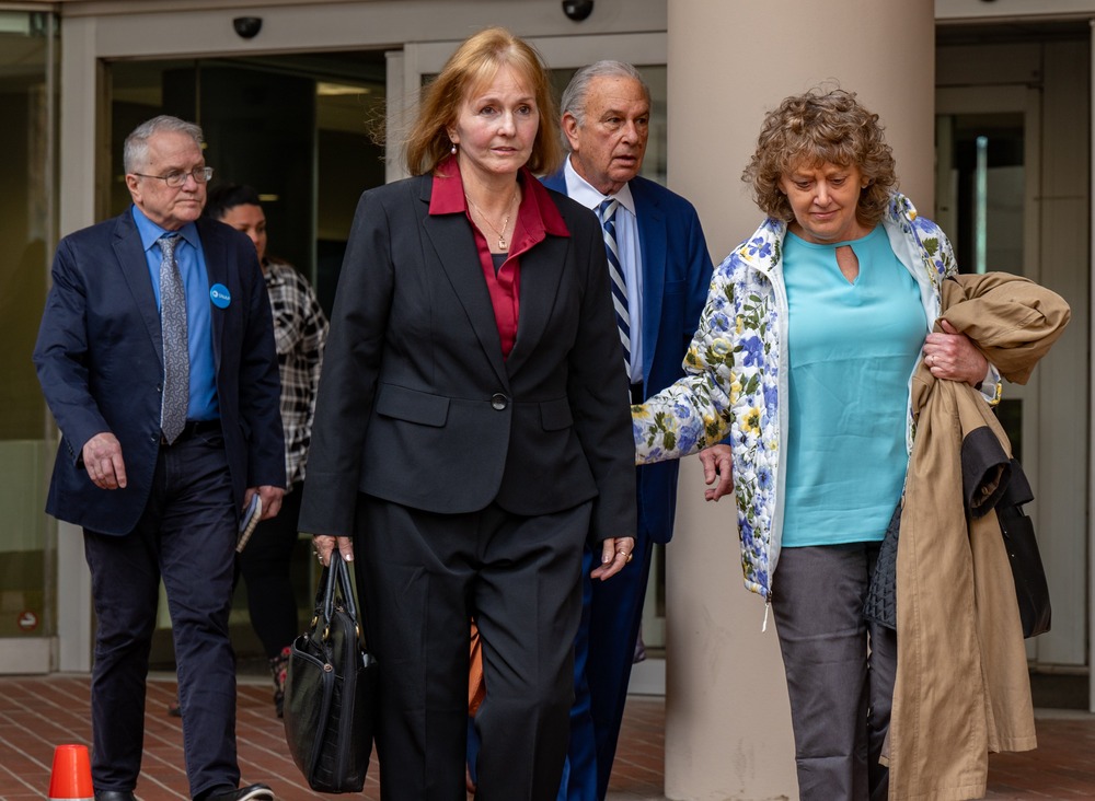 Woman leaves courthouse followed by group