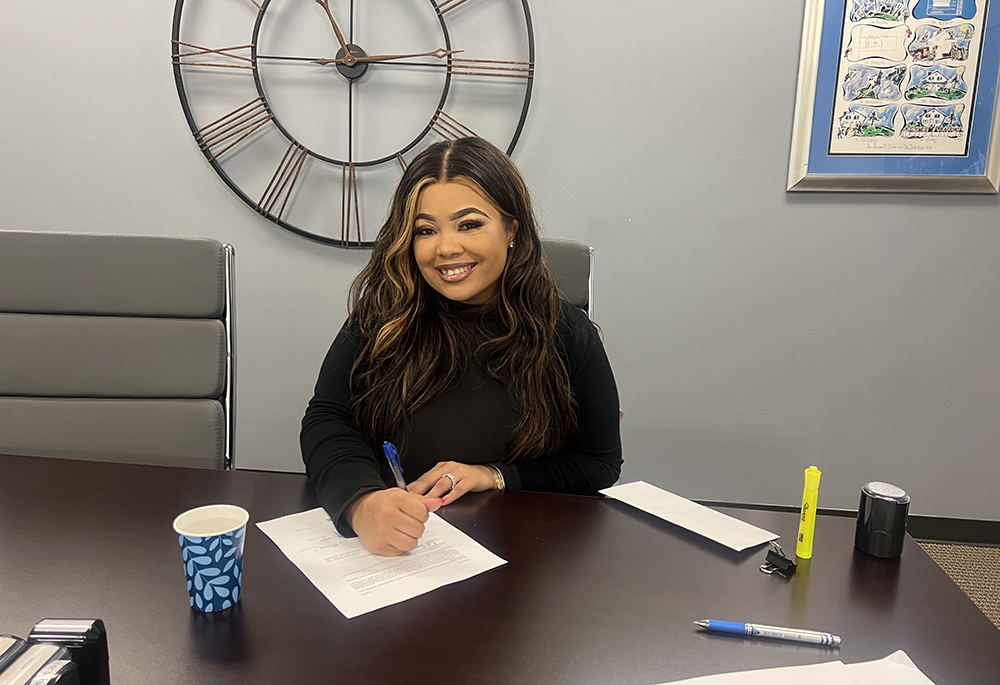 A'ja Ross, who resided for years in the transitional housing facilities at St. Ann's Center for Children, Youth and Families, signs paperwork for the purchase of her condo. (Courtesy of A'ja Ross)