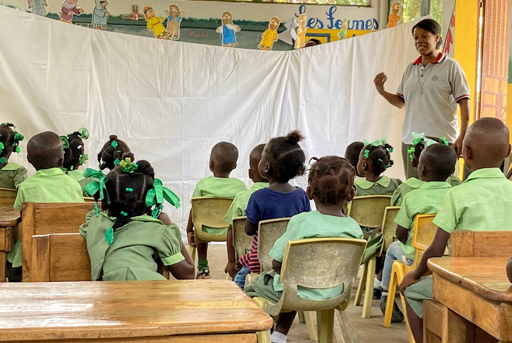 Haitian preschool students watch a stick puppet show in Haitian Creole written by Sr. Liz Cornejo, a member of the Religious of Jesus and Mary from Peru. (Patricia Dillon)