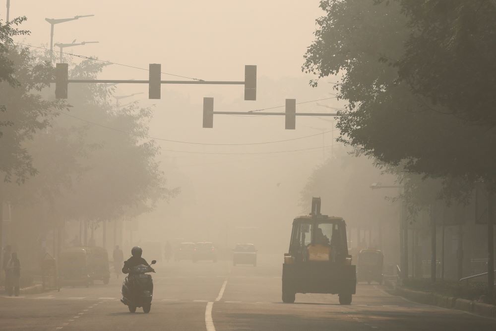 A motorcycle and bulldozer are seen on a smoggy morning in New Delhi, Nov. 17, 2023. Pollution and other environmental disasters attributed to climate change are the focus of delegates to the United Nations Climate Change Conference, known as COP28, being held Nov. 30 to Dec. 12 in Dubai, United Arab Emirates. (OSV News/Reuters/Anushree Fadnavis)