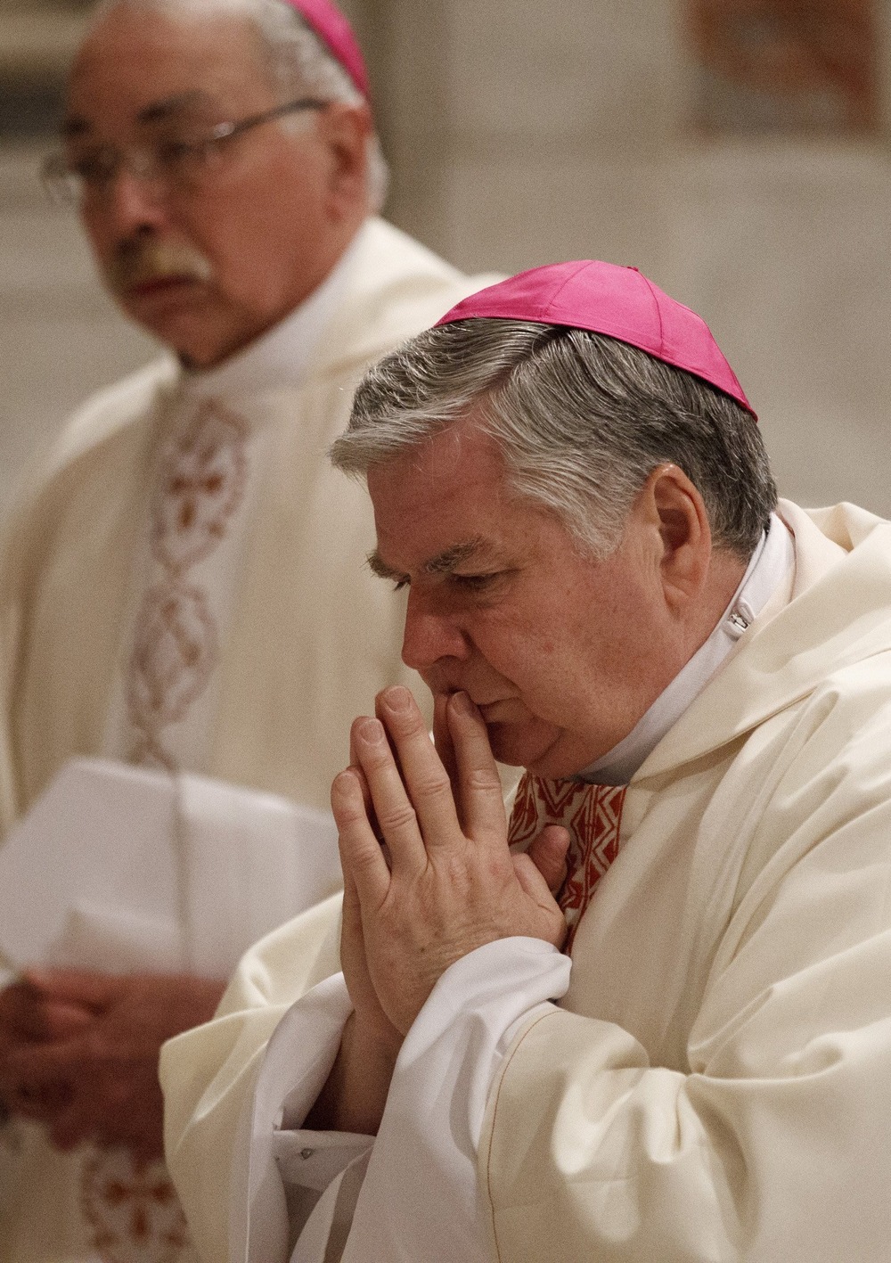 Bishop, vested, prays