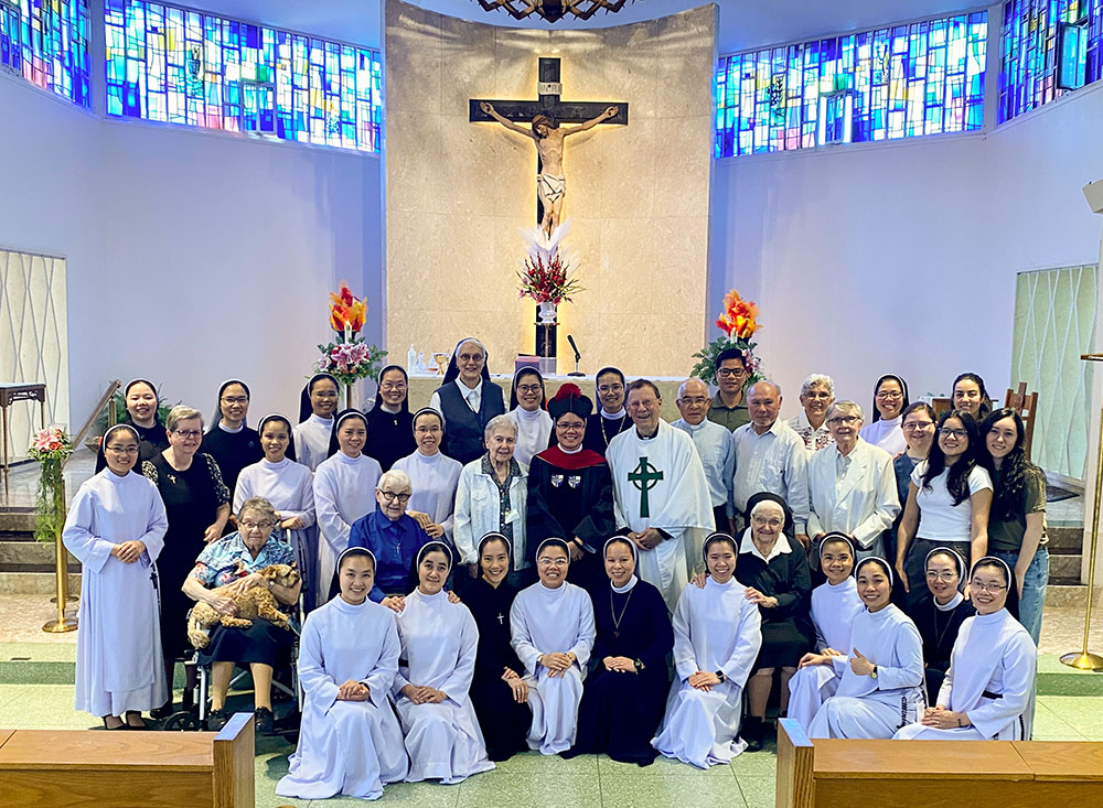 The Brockton community poses for a photo to celebrate one of the Vietnamese sisters graduating from a doctoral program in May 2024. (Courtesy of Maria Yen Do)