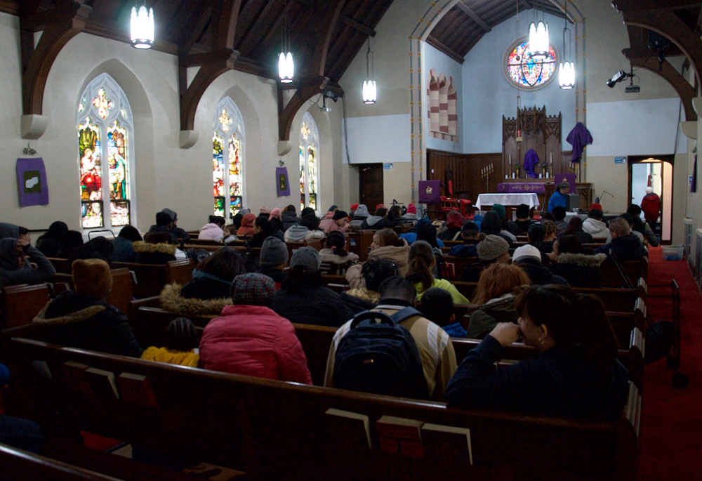 Neighbors wait inside Christus Lutheran Church's sanctuary for the SSJ Neighborhood Center's monthly food distribution to start, on March 20 in Camden, New Jersey. (GSR photo/Dan Stockman)