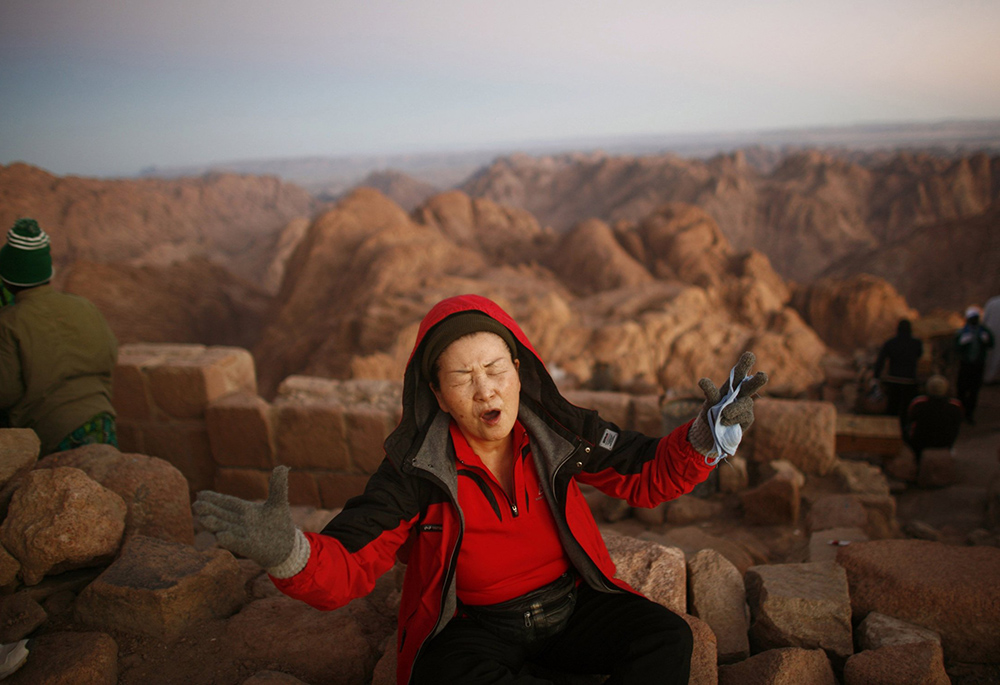 Pictured is a woman praying on Mount Moses in Sinai, Egypt. (CNS file photo/Reuters/Goran Tomasevic)