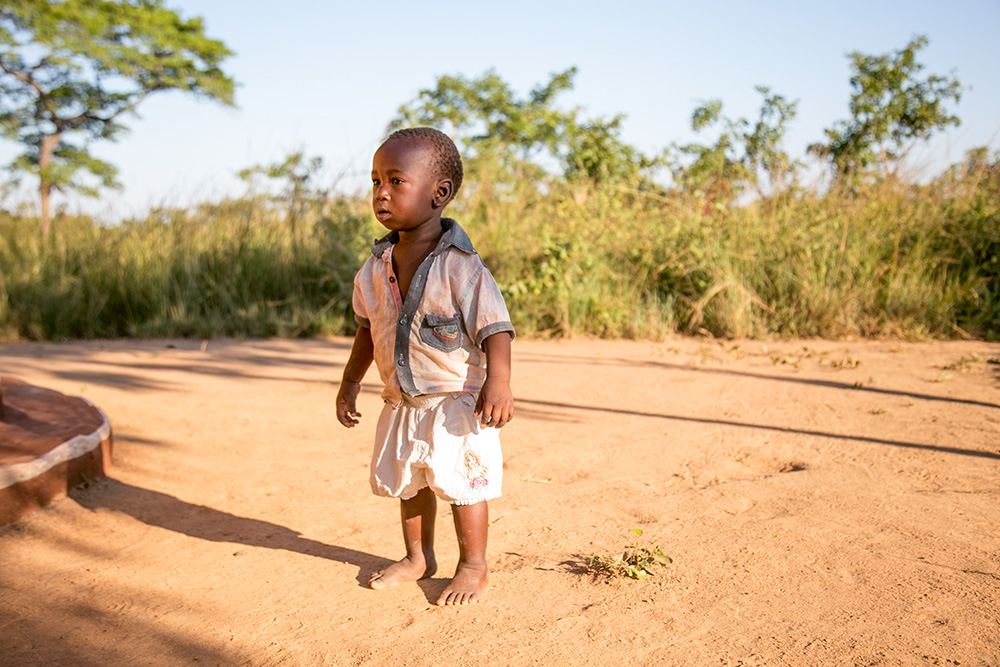 A Zambian child stands outside his home in the village of Ndombi. Crippling drought in Zambia has devastated agricultural production and caused extensive crop failure, leading to a food crisis that is mirrored across Africa and elsewhere in the tropics. (CNS/CRS/Michael Stulman)