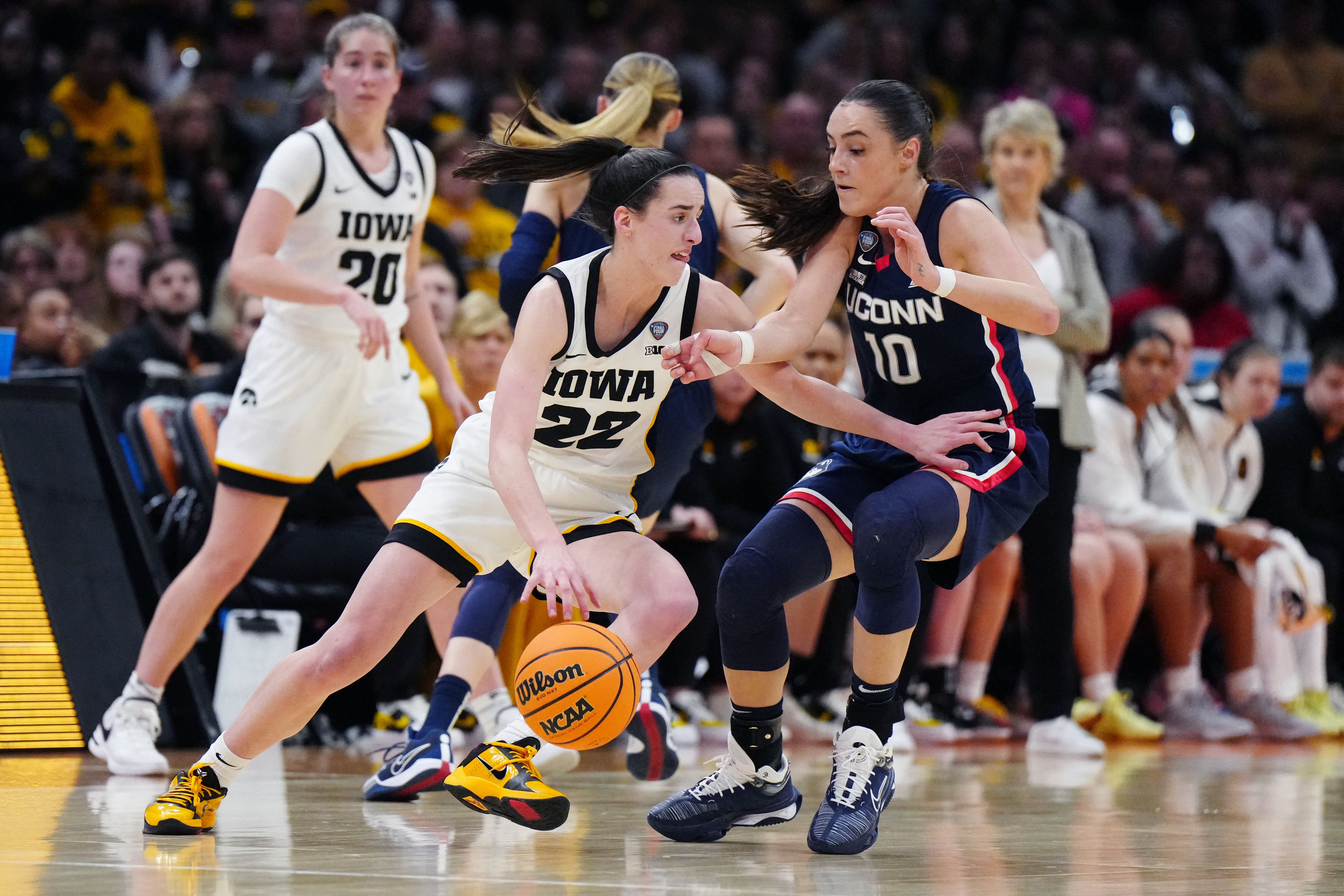 Iowa Hawkeyes guard Caitlin Clark (22) controls the ball against Connecticut Huskies guard Nika Muhl (10) in the Final Four of the women's 2024 NCAA Tournament April 5. Clark, the NCAA basketball all-time scoring record holder, now plays for the WNBA's Indiana Fever. 