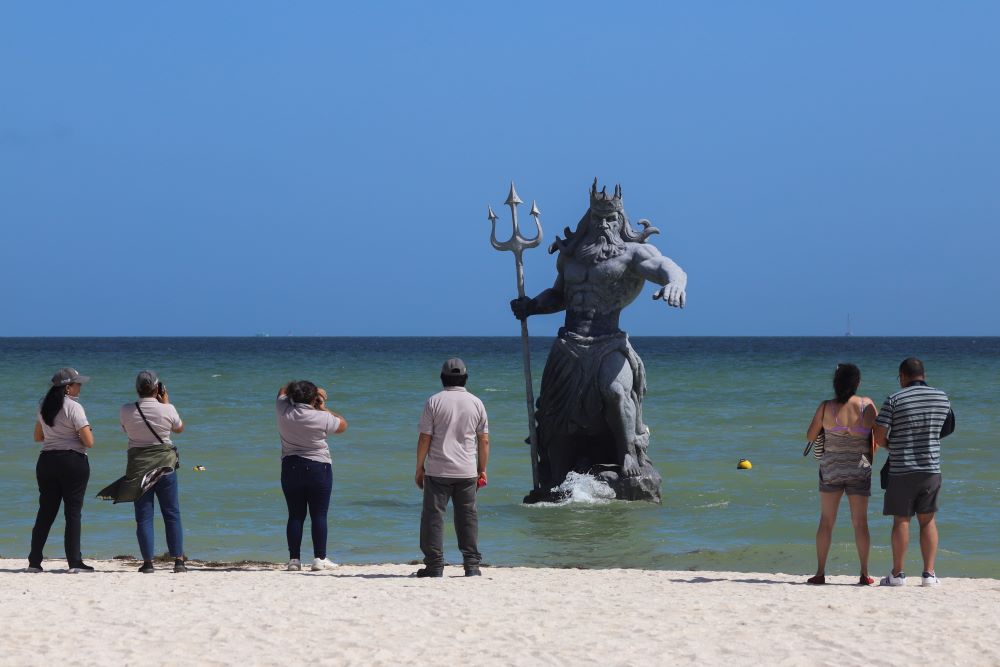 Tourists take pictures of a Poseidon sculpture before the arrival of Hurricane Beryl in Progreso, Yucatan, Mexico, July 4.