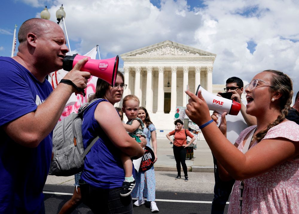 An abortion opponent and a supporter of legal abortion square off with megaphones in front of the U.S. Supreme Court in Washington June 24, 2023, the first anniversary the court's 2022 ruling in Dobbs v. Jackson Women