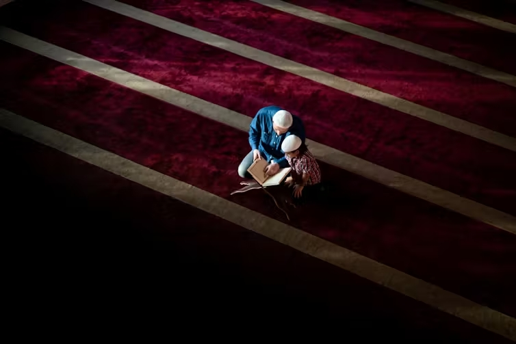 Two people talk in empty mosque