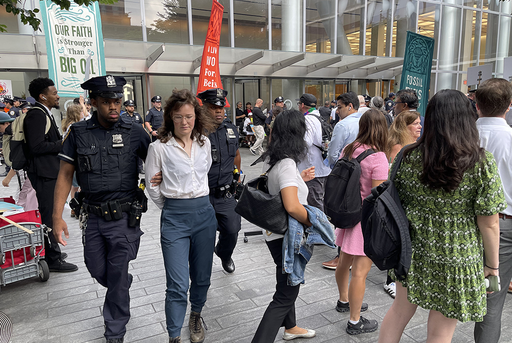 A demonstrator, Lina Blout of Earth Quaker Action Team, is arrested and dragged by the New York Police Department outside Citigroup’s headquarters on July 30 in New York. (NCR photo/Camillo Barone)